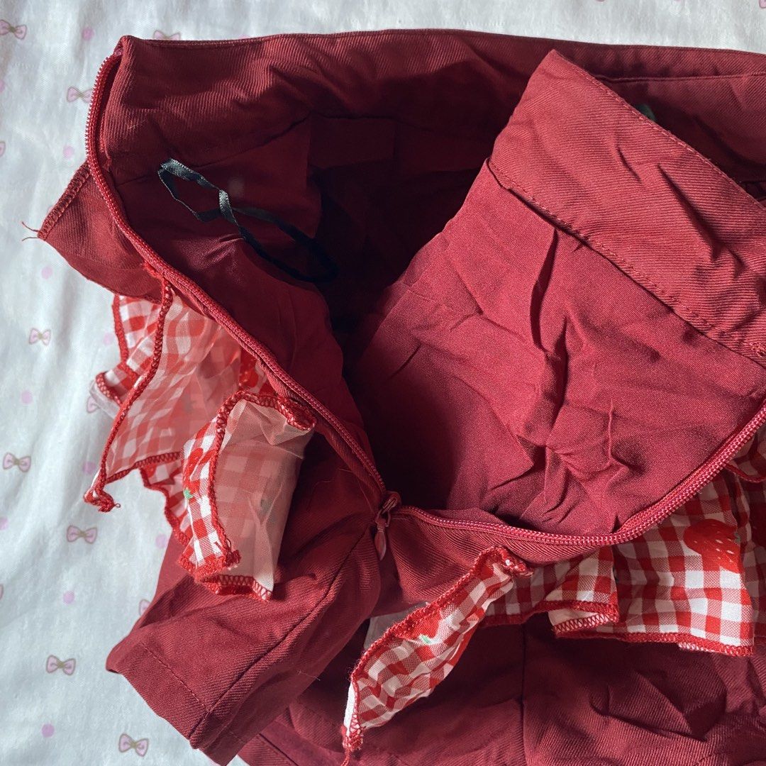 Red Gingham Strawberry Ruffle Shorts with Cherry Charm (Category: Shorts) located in Abulug. Submitted by dear_darlingdoll (Listing ID 1466287551, Image 3). Description: Maroon shorts with layered red and white gingham strawberry print ruffles. Small felt cherry charm pinned on the front waistband. Side zipper closure. Tag says size S. Hand wash only, no bleach, do not tumble dry. Fun coordinates for sweet casual outfits..