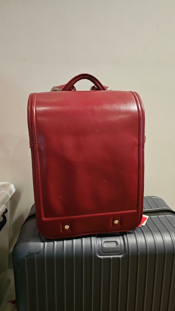 Red Japanese Randoseru School Backpack (Category: Backpacks) located in Quezon. Submitted by cgmhe (Listing ID 1466180856, Image 1). Description: Traditional Japanese randoseru school bag in deep red. Sturdy structured leather-like design with a flap closure, metal clasp hardware, and white padded shoulder straps. Built with multiple compartments and side D-rings. Classic boxy shape holds books and daily gear securely. Used condition with minor s