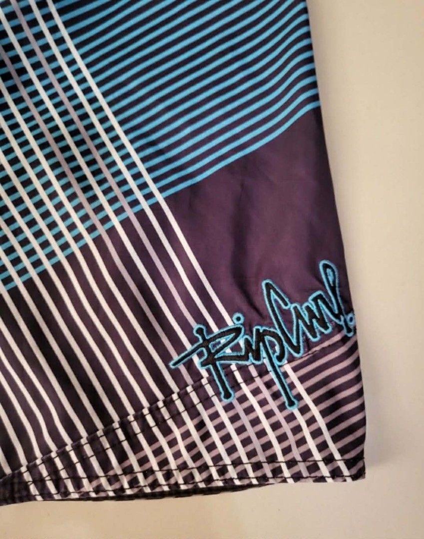 Rip Curl Plaid Boardshorts Swim Trunks (Category: Swim Trunks & Board Shorts) located in Bulacan. Submitted by clutsngo (Listing ID 1466185499, Image 3). Description: -450php shipped - Brand: Rip Curl - Style: Boardshorts / Surf wear - Design: Dark purple, blue, and white geometric plaid pattern - Details: Drawstring closure with branded eyelets and interior woven waist tag - Storage: Small back right pocket with flap closure - Branding: Embroide