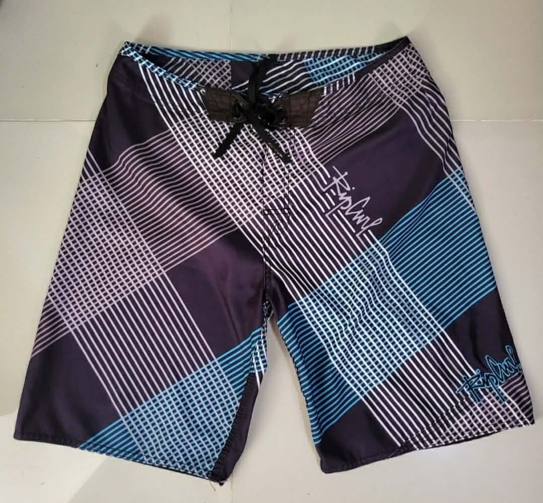 Rip Curl Plaid Boardshorts Swim Trunks (Category: Swim Trunks & Board Shorts) located in Bulacan. Submitted by clutsngo (Listing ID 1466185499, Image 1). Description: -450php shipped - Brand: Rip Curl - Style: Boardshorts / Surf wear - Design: Dark purple, blue, and white geometric plaid pattern - Details: Drawstring closure with branded eyelets and interior woven waist tag - Storage: Small back right pocket with flap closure - Branding: Embroide