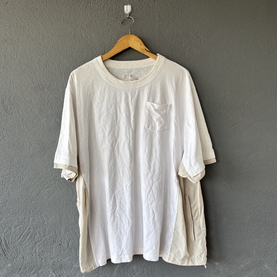 Sacai tee (Category: Tshirts & Polo Shirts ) located in San Fernando. Submitted by diff.thr1ft (Listing ID 1466170739, Image 1). Description: - Brand: Sacai - Color: White with beige layered panels - Material: 100% Cotton body with polyester attached parts - Features: Chest pocket, unique functional side zipper pockets - Origin: Made in Japan - Condition: Excellent pre-owned condition Fit large to xl.