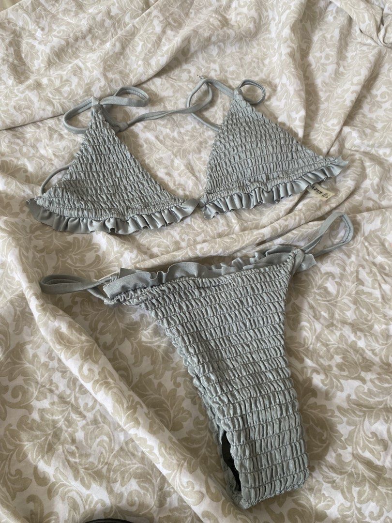 Sage Green Ruffle Smocked Bikini Set (Category: Bikinis & Swimsuits) located in Rizal. Submitted by mochimchim29 (Listing ID 1466301840, Image 1). Description: - Color: Sage green - Style: Two-piece bikini set with matching bottoms - Material: Super stretchy, textured smocked fabric - Top: Triangle design with adjustable straps - Bottoms: Cute ruffle trim details - Condition: Brand new with tag attached - Perfect for: Beach trips and pool parties
