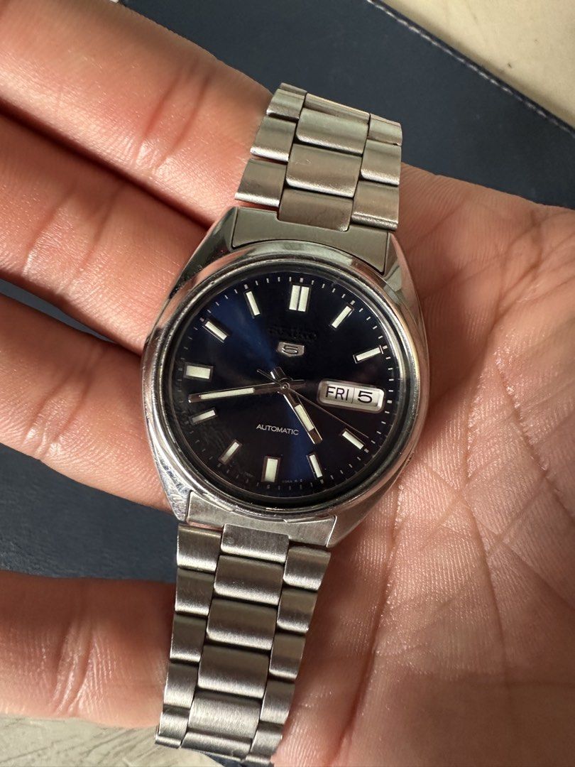 Seiko 5 SNXS77K (Category: Men's Watches) located in Manila. Submitted by hamzackerburg (Listing ID 1466276821, Image 1). Description: Classic Seiko 5 automatic watch featuring a deep blue sunburst dial and stainless steel bracelet. Powered by the reliable 7S26 mechanical movement. Day and date display positioned at 3 o'clock. Includes the original display box, hang tag, and extra bracelet links. Case and bracelet show light wear consistent with 