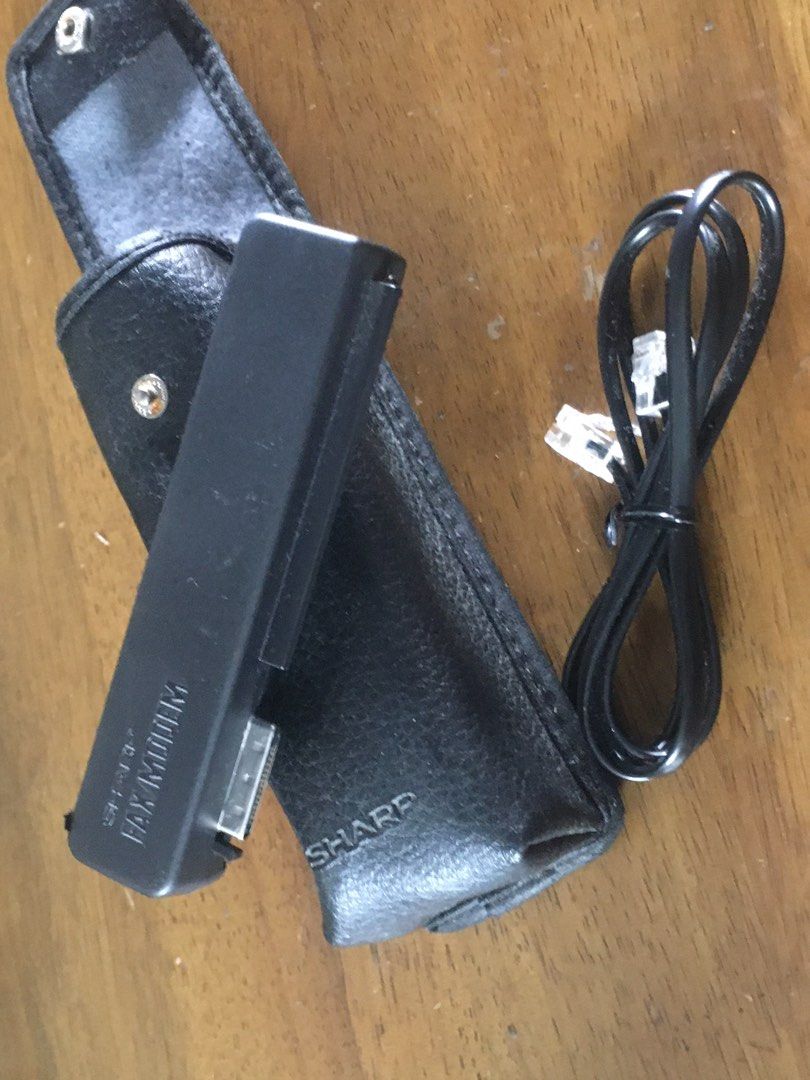 Sharp Fax Modem with Leather Case and Cable (Category: Office & Business Technology) located in Tanza. Submitted by surplusphone (Listing ID 1466160089, Image 1). Description: - Authentic vintage Sharp fax modem unit in sleek black - Includes a matching black leather carrying case with Sharp branding - Comes with a coiled black telephone cable with connectors - Perfect for retro tech setups, office display, or collection - Clean exterior on both 