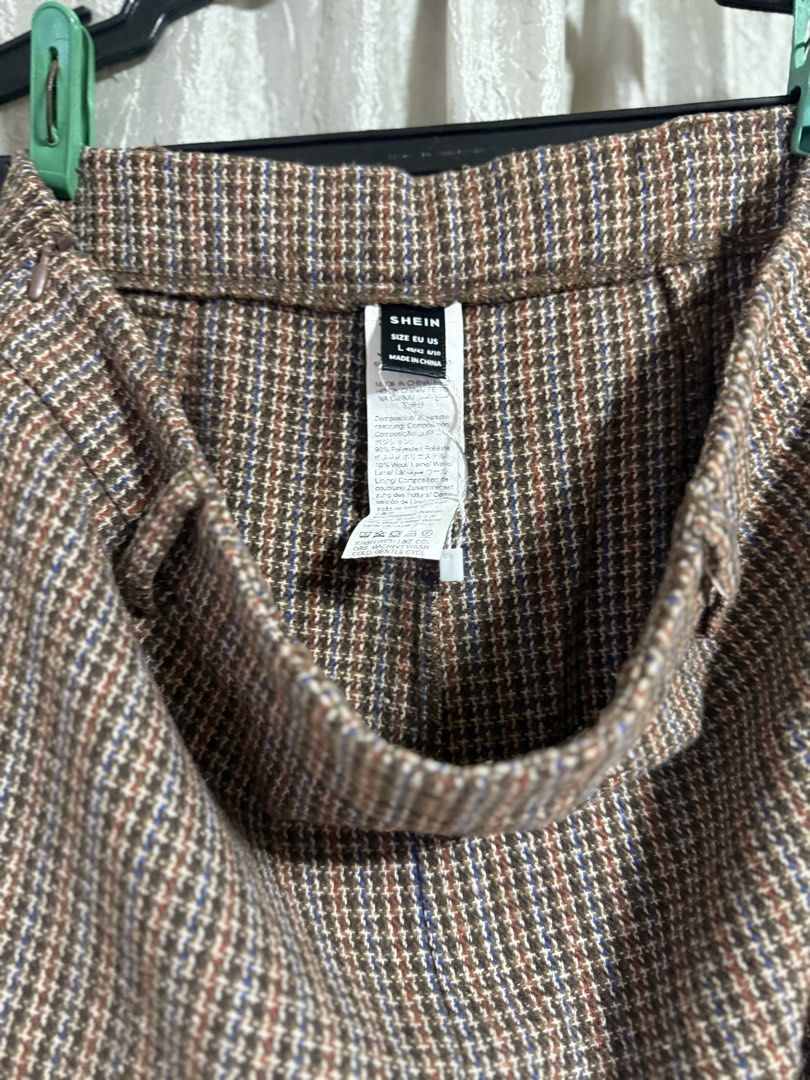 Shein Brown Houndstooth Plaid Trousers Size L (Category: Trousers) located in Manila. Submitted by lilomochi (Listing ID 1466291761, Image 2). Description: Brown houndstooth plaid trousers from Shein. Features a patterned plaid design with subtle blue and orange threads running through. Size L, EUR 40/42, US 8/10. Belt loops attached at the waistband. Straight cut style, great for casual days or office wear..