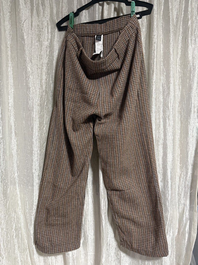 Shein Brown Houndstooth Plaid Trousers Size L (Category: Trousers) located in Manila. Submitted by lilomochi (Listing ID 1466291761, Image 1). Description: Brown houndstooth plaid trousers from Shein. Features a patterned plaid design with subtle blue and orange threads running through. Size L, EUR 40/42, US 8/10. Belt loops attached at the waistband. Straight cut style, great for casual days or office wear..