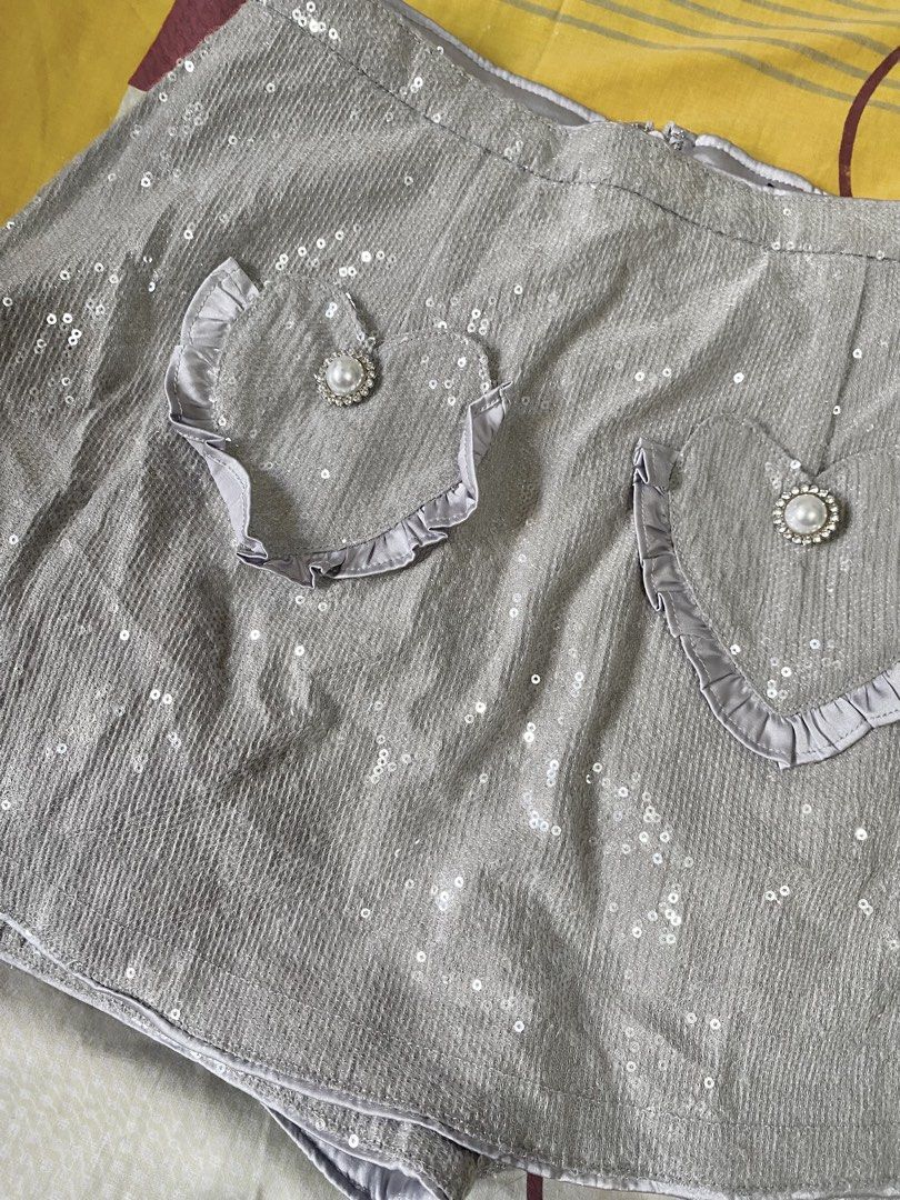 Silver Sequin Heart Pocket Skort Shorts (Category: Shorts) located in Manila. Submitted by stormibutterfly26 (Listing ID 1466199856, Image 2). Description: Sparkly silver sequin skort featuring built-in shorts, cute heart-shaped ruffled pockets with faux pearl rhinestone buttons, and a back zipper. Perfect for parties and festivals! PM for inquiries..