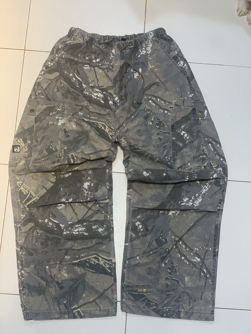 SMILE DDD Grey Camo Cargo Pants (Category: Jeans) located in Mataasnakahoy. Submitted by grailsph.81630 (Listing ID 1466276969, Image 1). Description: - Brand new with original tags attached (BNWT) - Size: L - Design: Grey camouflage with a unique tree bark pattern - Fit: Straight leg with an adjustable elastic waistband and drawstring - Features: Multiple utility pockets and classic label patch on the back pocket 26-34 x 40.