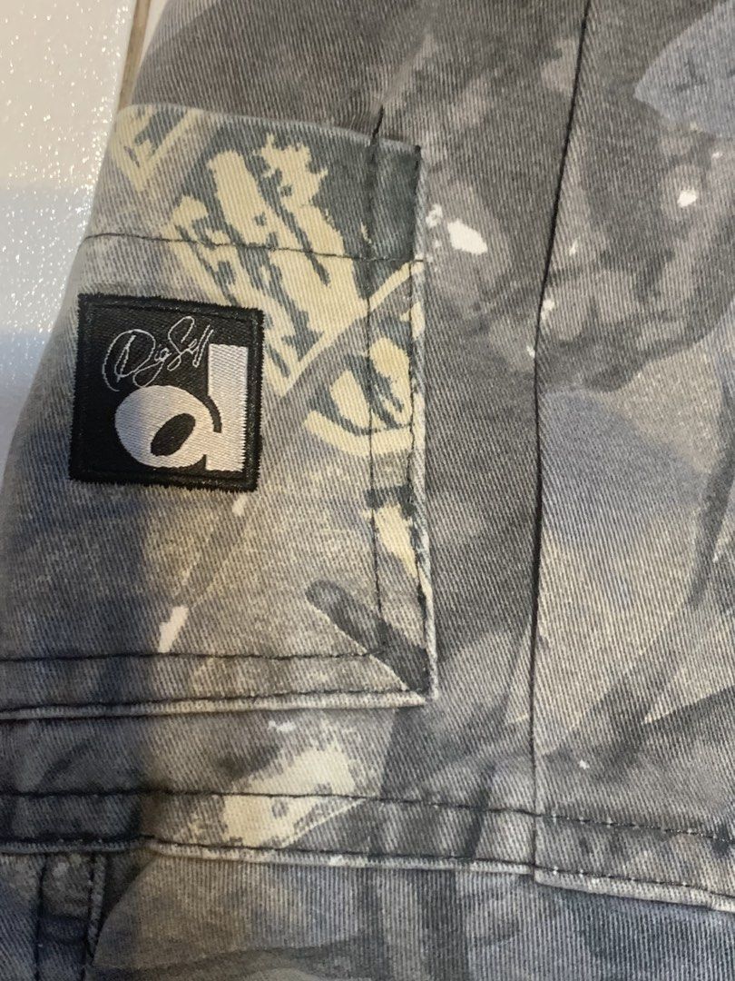 SMILE DDD Grey Camo Cargo Pants (Category: Jeans) located in Mataasnakahoy. Submitted by grailsph.81630 (Listing ID 1466276969, Image 2). Description: - Brand new with original tags attached (BNWT) - Size: L - Design: Grey camouflage with a unique tree bark pattern - Fit: Straight leg with an adjustable elastic waistband and drawstring - Features: Multiple utility pockets and classic label patch on the back pocket 26-34 x 40.
