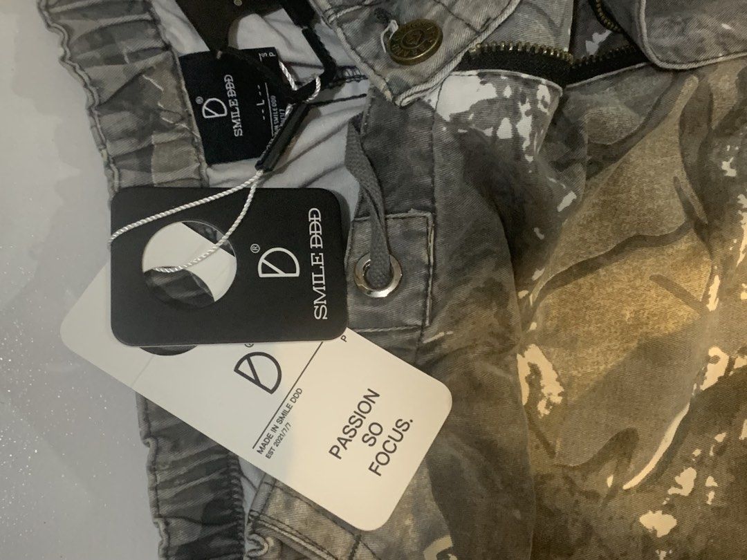 SMILE DDD Grey Camo Cargo Pants (Category: Jeans) located in Mataasnakahoy. Submitted by grailsph.81630 (Listing ID 1466276969, Image 3). Description: - Brand new with original tags attached (BNWT) - Size: L - Design: Grey camouflage with a unique tree bark pattern - Fit: Straight leg with an adjustable elastic waistband and drawstring - Features: Multiple utility pockets and classic label patch on the back pocket 26-34 x 40.