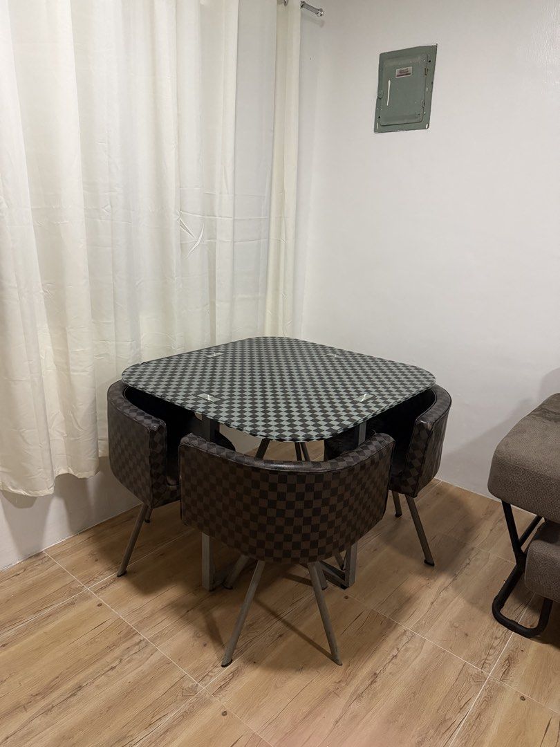 Space-Saving 4-Chair Dining Set (Checkered Pattern) (Category: Tables & Sets) located in Rizal. Submitted by lunaxkitkat (Listing ID 1466279779, Image 2). Description: Selling a compact 4-seater dining table set with matching curved chairs in a classic black and brown checkered pattern. Perfect for small apartments, condos, or studio spaces! Space-Saving Design: Chairs tuck completely underneath the table frame when not in use to maximize floor a