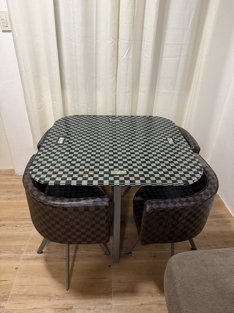 Space-Saving 4-Chair Dining Set (Checkered Pattern) (Category: Tables & Sets) located in Rizal. Submitted by lunaxkitkat (Listing ID 1466279779, Image 1). Description: Selling a compact 4-seater dining table set with matching curved chairs in a classic black and brown checkered pattern. Perfect for small apartments, condos, or studio spaces! Space-Saving Design: Chairs tuck completely underneath the table frame when not in use to maximize floor a
