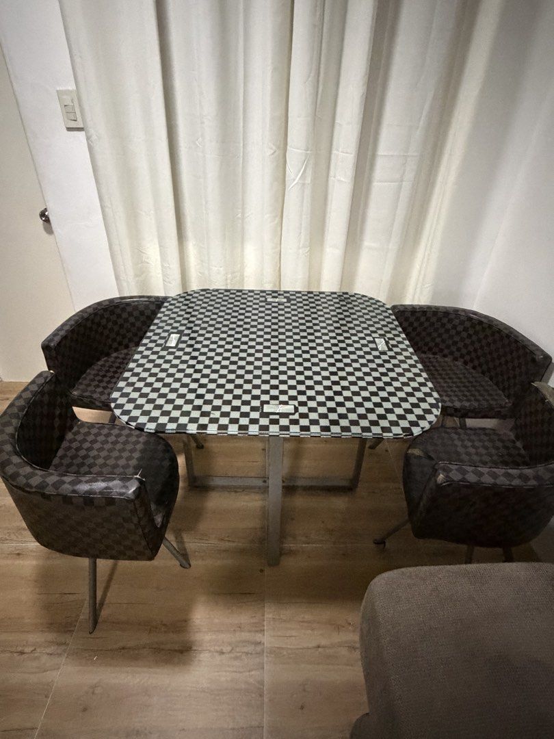 Space-Saving 4-Chair Dining Set (Checkered Pattern) (Category: Tables & Sets) located in Rizal. Submitted by lunaxkitkat (Listing ID 1466279779, Image 3). Description: Selling a compact 4-seater dining table set with matching curved chairs in a classic black and brown checkered pattern. Perfect for small apartments, condos, or studio spaces! Space-Saving Design: Chairs tuck completely underneath the table frame when not in use to maximize floor a