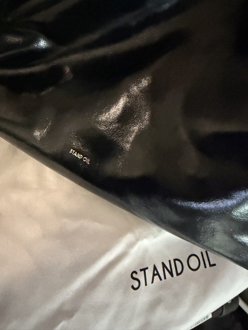 Stand Oil Ringo Black Hobo Bag (Category: Shoulder Bags) located in Quezon City. Submitted by kcobs (Listing ID 1466235928, Image 3). Description: - Brand/Model: Stand Oil glossy black shoulder bag - Style: Sleek hobo design with clean and minimal aesthetic - Features: Adjustable strap, convenient exterior zipper pocket on the back, and super spacious interior - Interior: Fully lined with stylish cream fabric - Inclusions: Comes with original dus