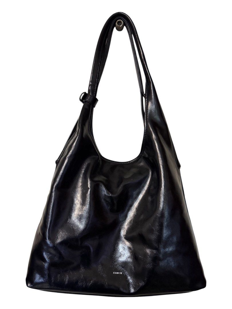 Stand Oil Ringo Black Hobo Bag (Category: Shoulder Bags) located in Quezon City. Submitted by kcobs (Listing ID 1466235928, Image 1). Description: - Brand/Model: Stand Oil glossy black shoulder bag - Style: Sleek hobo design with clean and minimal aesthetic - Features: Adjustable strap, convenient exterior zipper pocket on the back, and super spacious interior - Interior: Fully lined with stylish cream fabric - Inclusions: Comes with original dus