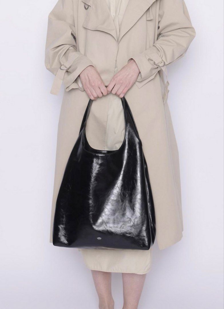 Stand Oil Ringo Black Hobo Bag (Category: Shoulder Bags) located in Quezon City. Submitted by kcobs (Listing ID 1466235928, Image 2). Description: - Brand/Model: Stand Oil glossy black shoulder bag - Style: Sleek hobo design with clean and minimal aesthetic - Features: Adjustable strap, convenient exterior zipper pocket on the back, and super spacious interior - Interior: Fully lined with stylish cream fabric - Inclusions: Comes with original dus