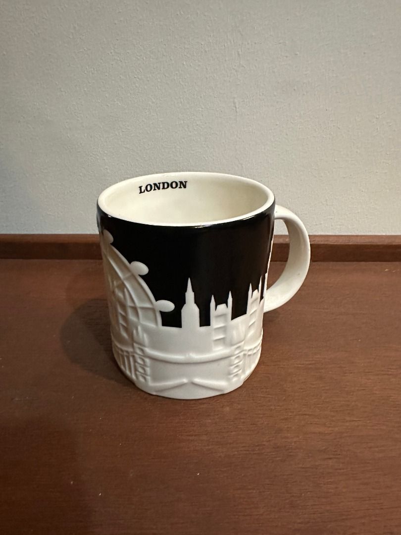 Starbucks London Skyline Ceramic Coffee Mug (Category: Coffee & Tea Tableware) located in San Juan City. Submitted by looneyc (Listing ID 1466290781, Image 1). Description: - Authentic Starbucks London City Mug - Color: Black and white ceramic with a pop of red - Design: Raised 3D architectural skyline featuring London landmarks, the London Eye, and a classic telephone booth - Branding: Starbucks siren logo next to the phone box, with 'LONDON' pr