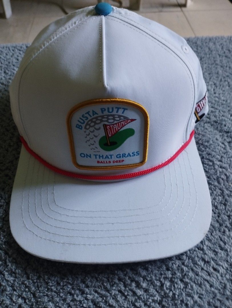 Staunch Traditional Busta Putt Snapback Hat White (Category: Caps & Hats) located in Manila. Submitted by happycaps (Listing ID 1466178189, Image 1). Description: - Brand: Staunch - Color: Clean white with red rope accent and blue top button - Design: Front patch with golf graphic and 'Busta Putt On That Grass Balls Deep' text - Details: Embroidered side flag logo, branded interior taping, and red woven tag above closure - Fit: Adjustable black p