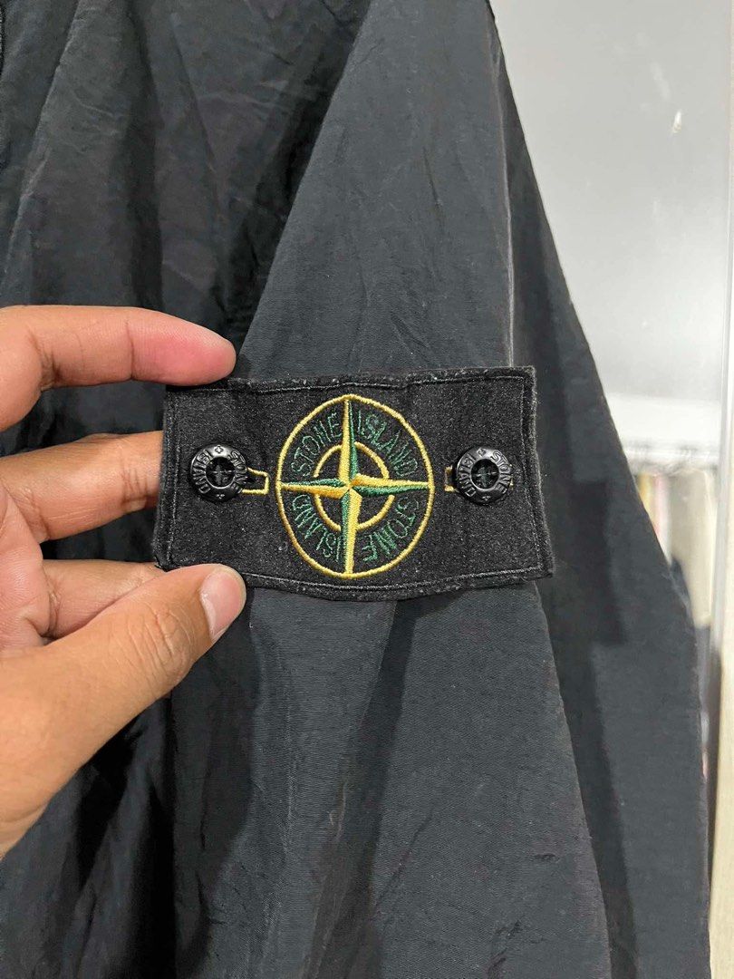 Stone Island Black Anorak Jacket Size L (Category: Coats, Jackets and Outerwear) located in Cabuyao City. Submitted by undergroundthrift03 (Listing ID 1466319334, Image 2). Description: Black Stone Island anorak jacket in size large. Half-zip front closure with a chest pocket and drawstring hem. Classic compass badge on the left sleeve. Ribbed cuffs with grey striped detailing. Certilogo authentication tag attached inside with code visible. Light