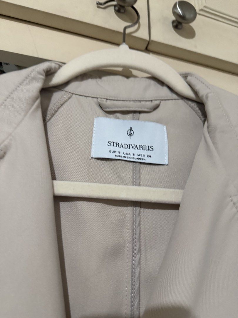 Stradivarius Beige Trench Coat Size S (Category: Coats, Jackets and Outerwear) located in Pasay City. Submitted by anneeemariequa (Listing ID 1466268294, Image 2). Description: - Brand: Stradivarius - Size: S - Color: Classic beige - Style: Double-breasted trench coat with matching waist belt and tortoiseshell buttons - Details: Classic collar neckline, long sleeves, clean fabric with no flaws - Ideal for: Layering during cooler weather or rainy 