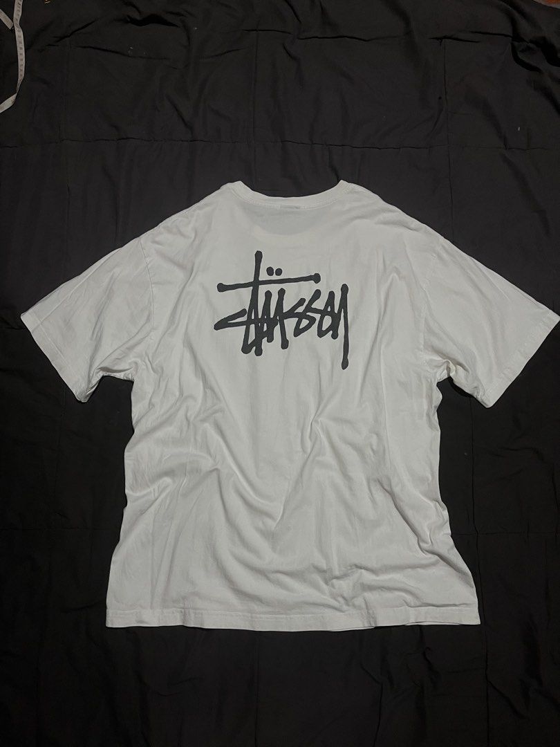 Stüssy basic stock logo white tee shirt (Category: Tshirts & Polo Shirts ) located in Davao. Submitted by bothwiseph (Listing ID 1466303522, Image 2). Description: - Brand: Stüssy - Color: White - Fit: Relaxed fit, crew neck, short sleeves - Design: Small black signature logo on left chest, large logo printed on the back - Style: Classic streetwear, versatile for casual everyday wear.