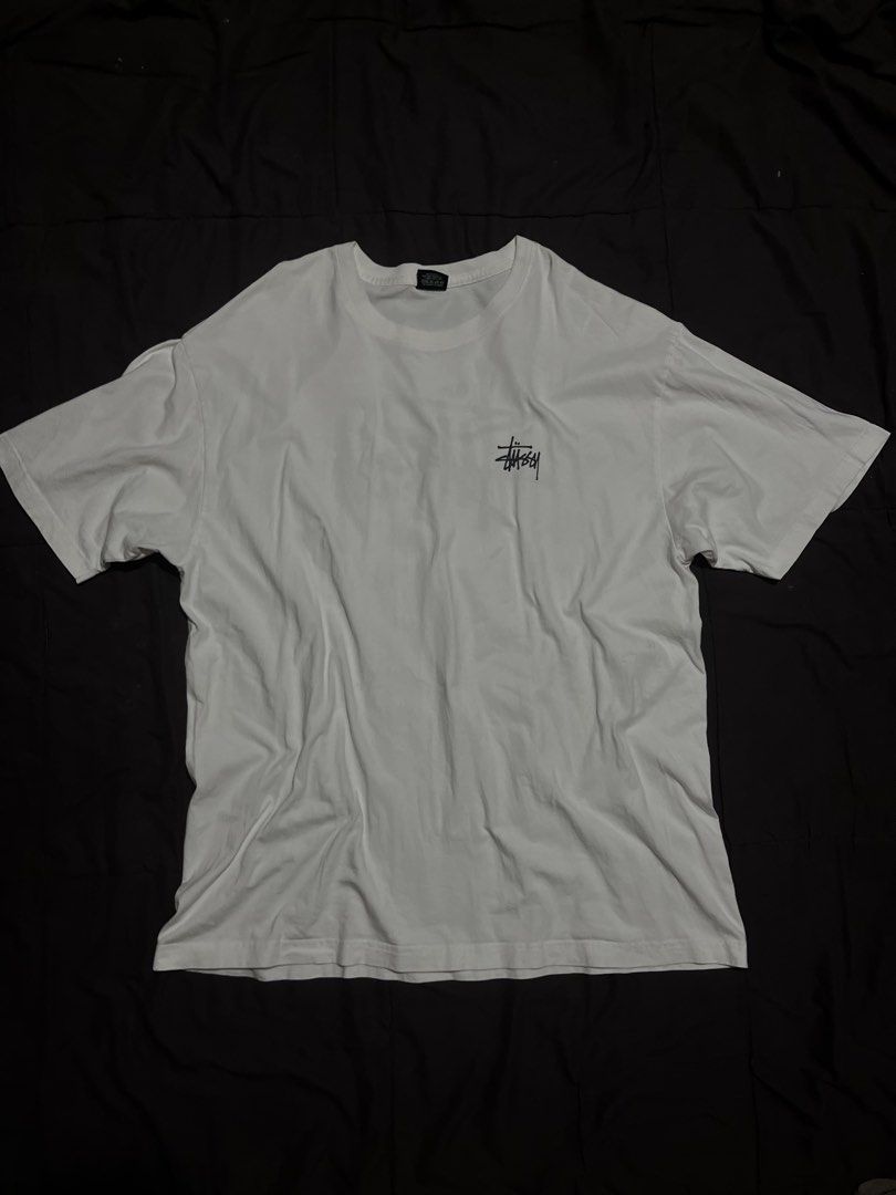 Stüssy basic stock logo white tee shirt (Category: Tshirts & Polo Shirts ) located in Davao. Submitted by bothwiseph (Listing ID 1466303522, Image 1). Description: - Brand: Stüssy - Color: White - Fit: Relaxed fit, crew neck, short sleeves - Design: Small black signature logo on left chest, large logo printed on the back - Style: Classic streetwear, versatile for casual everyday wear.
