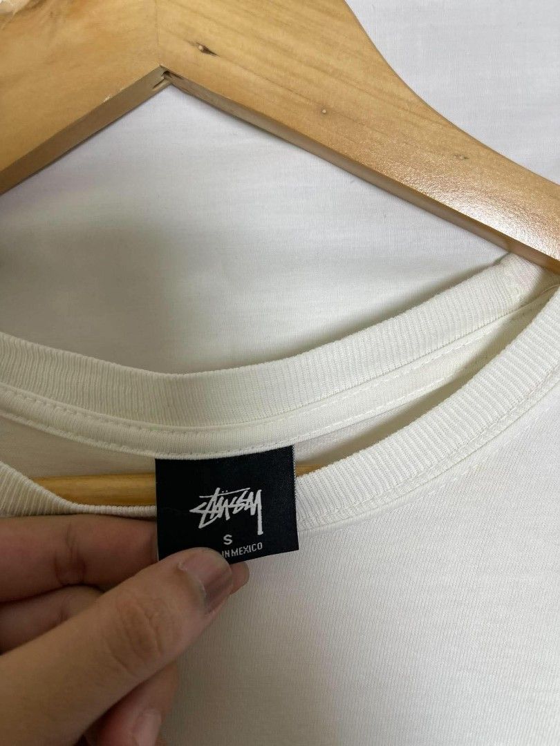 Stüssy White Graphic Tee (Category: Tshirts & Polo Shirts ) located in Manila. Submitted by japee55 (Listing ID 1466320941, Image 3). Description: - Brand: Stüssy - Color: White with black prints - Size: Small - Material: 100% Cotton (Made in Mexico) - Design: Small left chest logo and large signature back graphic - Fit: Standard crew neckline with short sleeves - Condition: Brand new / Excellent.
