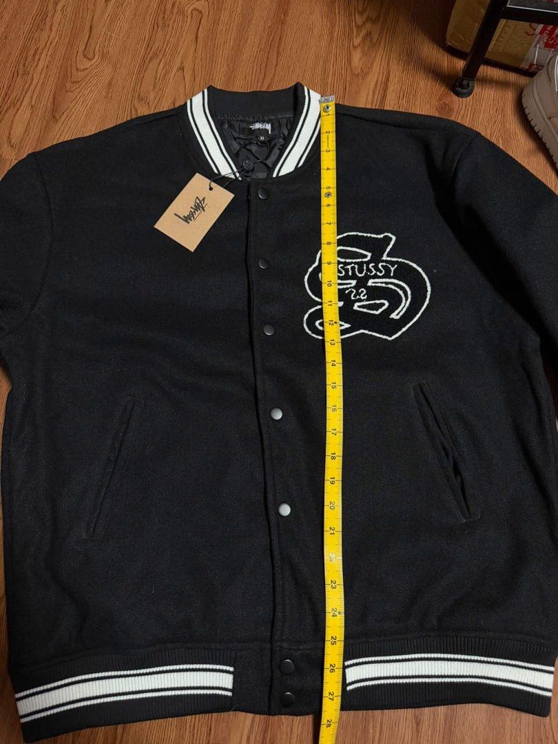 Stussy Black Varsity Jacket (Category: Coats, Jackets and Outerwear) located in Cainta. Submitted by tinpalma (Listing ID 1466307054, Image 3). Description: - Brand: Stussy - Condition: Brand new with tags (BNWT) - Color: Black with white embroidery on chest and back - Size: XL - Details: Striped ribbing on collar, cuffs, and hem, button-up front, and functional side pockets.