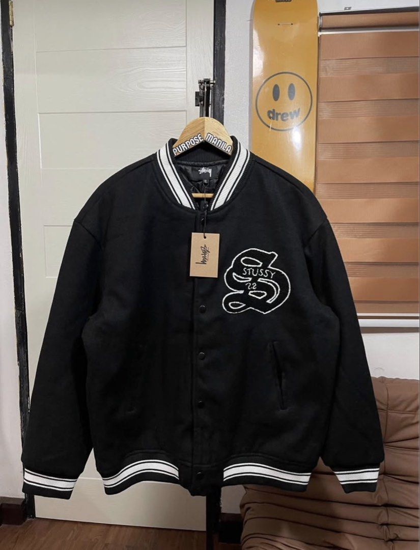 Stussy Black Varsity Jacket (Category: Coats, Jackets and Outerwear) located in Cainta. Submitted by tinpalma (Listing ID 1466307054, Image 1). Description: - Brand: Stussy - Condition: Brand new with tags (BNWT) - Color: Black with white embroidery on chest and back - Size: XL - Details: Striped ribbing on collar, cuffs, and hem, button-up front, and functional side pockets.