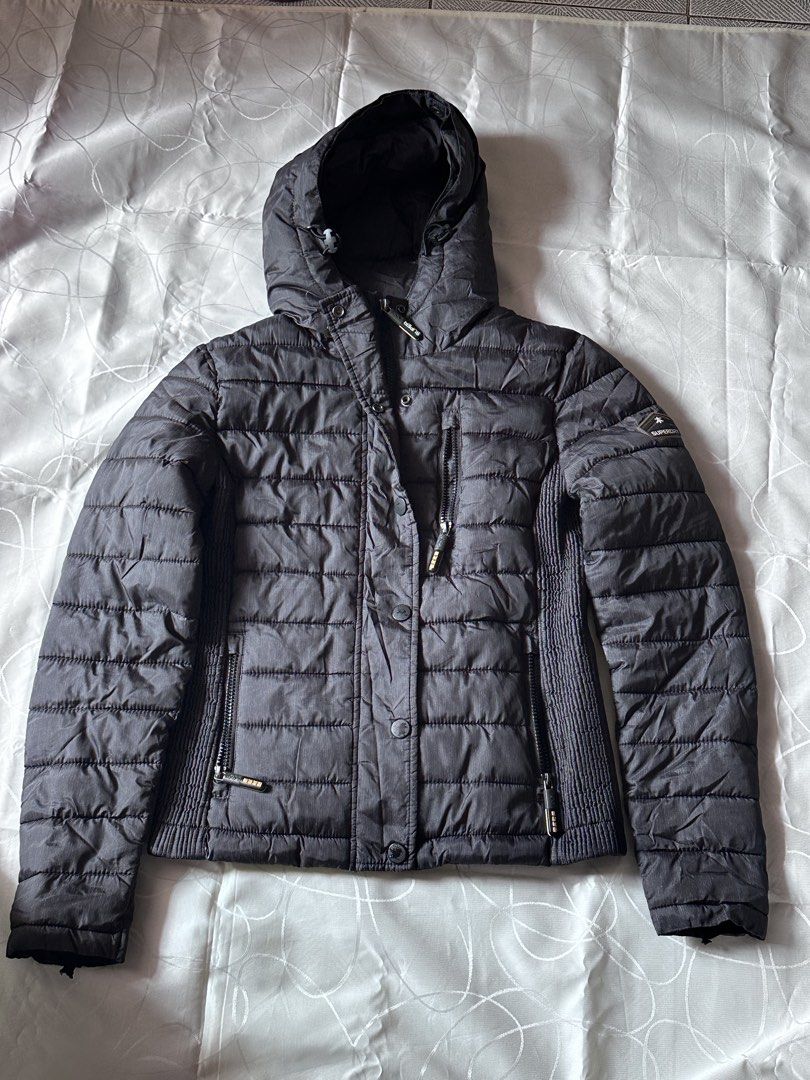 Superdry jacket （分類：外套及戶外衣服）位於 Hong Kong。 由 ayfha9373698 提交（商品編號 1466171246，圖片 2）。簡介： Superdry puffer jacket in dark grey and black mix. Zip and snap button front closure, plus zip pockets on the chest and sides. Ribbed stretch panels along the sides for movement. Attached hood with drawstrings. Superdry Mountain Goods logo patch on the left sleeve. Warm and practical layer for colder days.。