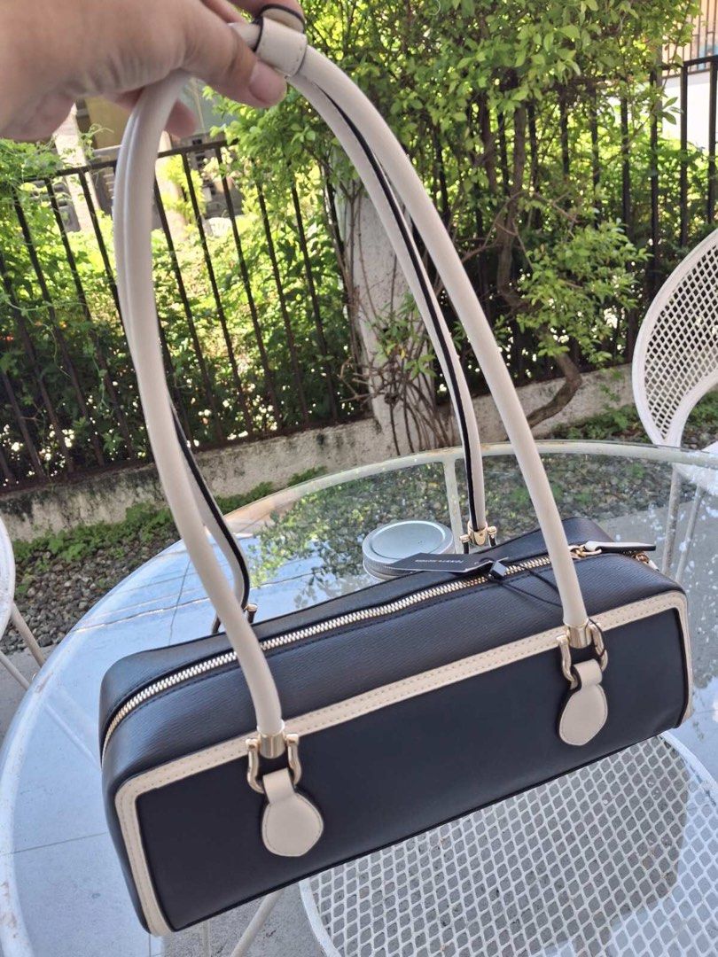 Tommy Hilfiger Shoulder Bag (Category: Shoulder Bags) located in Manila. Submitted by bubuamponin (Listing ID 1466184238, Image 2). Description: - Color: Navy blue with white piping - Hardware: Gold-tone with metallic front logo - Closure: Secure zip top - Straps: Comfortable long straps - Condition: Brand new with hanging brand tag attached - Design: Clean, structured, and classic rectangular shape.