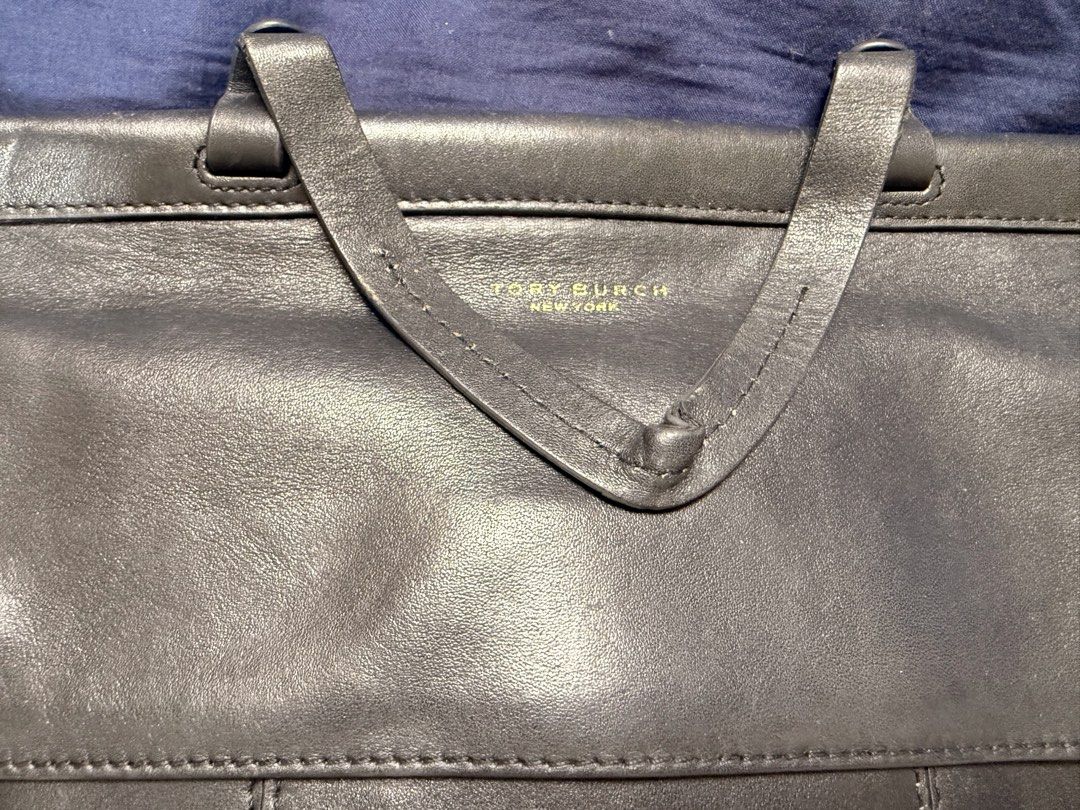 Tory Burch Black Leather Handbag with Strap (Category: Luxury Bags & Wallets) located in Manila. Submitted by rrtolibas48132 (Listing ID 1466285886, Image 2). Description: - Brand: Tory Burch - Color: Black with gold hardware - Material: Genuine leather - Features: Detachable matching leather strap, front flap with gold logo lettering, structured front and back panels - Interior: Lined with a zipper pocket and cutout T logo badge - Condition: Nor