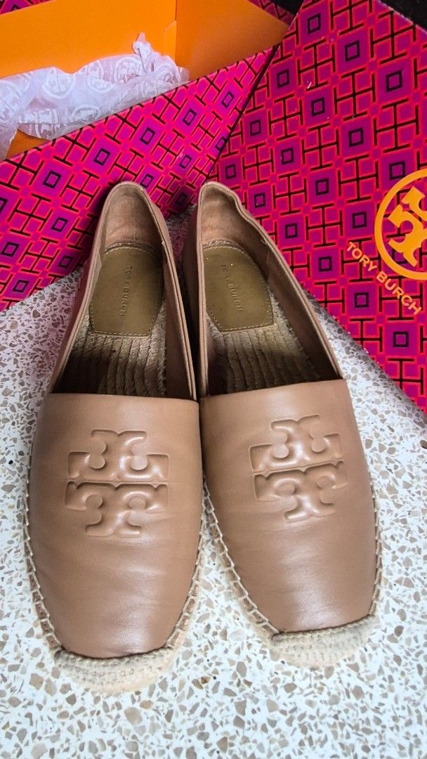 Tory Burch Leather Espadrilles Flat Shoes Tan Brown (Category: Flats & Sandals) located in Davao. Submitted by mommylove1422 (Listing ID 1466229321, Image 2). Description: - Authentic Tory Burch tan leather espadrilles - Features a stylish big embossed logo on top - Classic jute wrap around the midsole - Comfortable slip-on design with a flat rubber outsole - Condition: Clean overall with minimal wear on the soles - Includes original patterned bo