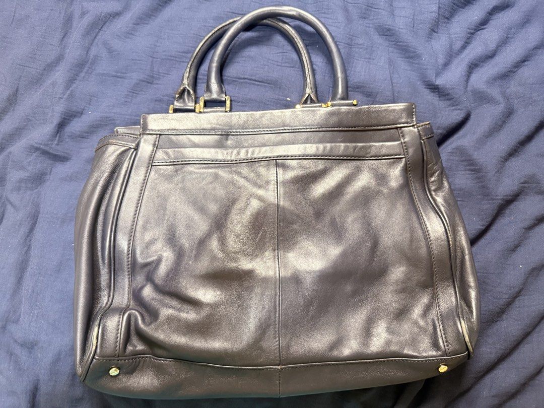 Tory Burch Leather Handbag (Category: Luxury Bags & Wallets) located in Manila. Submitted by rrtolibas48132 (Listing ID 1466285397, Image 2). Description: - Brand: Tory Burch - Color: Classic Navy Blue - Material: Genuine Leather with Gold-tone Hardware - Features: Debossed logo medallion, dual top handles, and a detachable shoulder strap - Closure & Interior: Top zip closure, fabric logo lining, and an interior zip pocket - Capacity: Very spacio