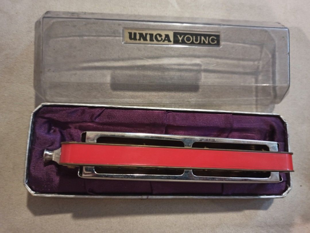 Unica Young Harmonica with Case (Category: Musical Instruments) located in Caloocan City. Submitted by rtarellano (Listing ID 1466206079, Image 2). Description: - Vintage Unica Young harmonica with original storage case - Clear plastic lid featuring the official branded label - Chrome-plated body with intricate engraved detailing and a striking red backing panel - Elegant interior lined with purple satin fabric - Excellent collectible item for mu