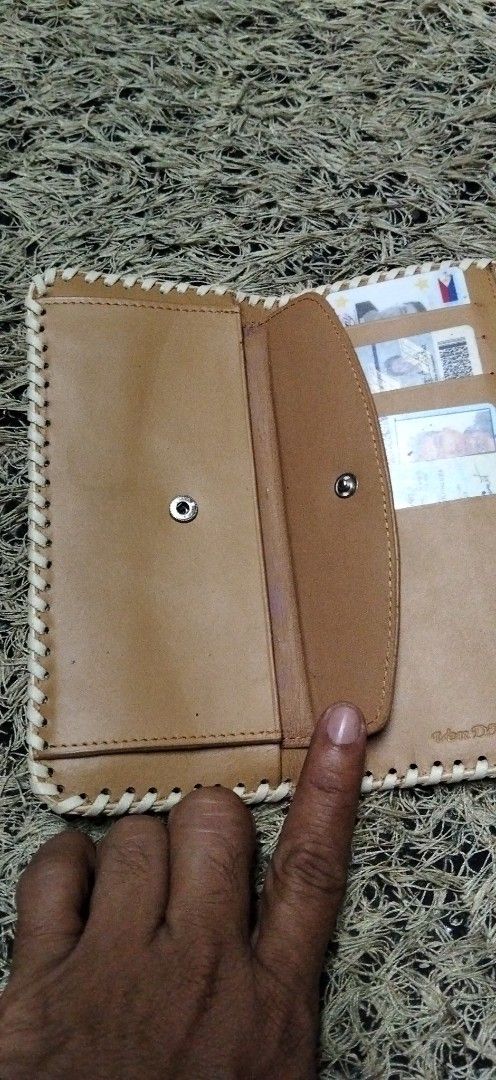 VenDome Long Wallet White Leather Whipstitch (Category: Wallets & Card holders) located in Paranaque City. Submitted by michael-08 (Listing ID 1466189193, Image 3). Description: - Brand: VenDome - Material: Genuine white leather with a textured bottom panel - Design: Contrast whipstitching and eagle emblem snap button - Interior: Tan leather lining - Storage: Multiple card slots, receipt pockets, clear ID slots, and zippered coin compartment - Co