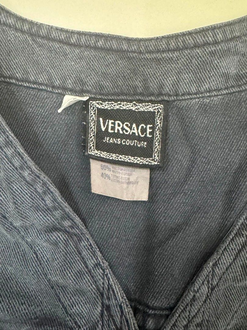 Versace Jeans Couture Denim Vest (Category: Vests) located in Lipa City. Submitted by cokelight11 (Listing ID 1466294768, Image 3). Description: - Versace Jeans Couture Sleeveless Denim Vest - Origin: Made in Italy by Manifatture Ititierre - Color/Wash: Washed dark grey / black - Material: 60% viscose, 40% cotton - Hardware: Signature gold-tone embossed Medusa head buttons - Details: Dual chest pockets and stylish pointed front hem - Size: EC (Fi