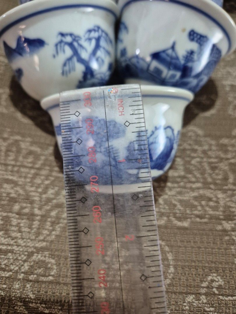 Vintage Blue and White Ceramic Teacups Bundle (Category: Coffee & Tea Tableware) located in Gattaran. Submitted by uploadtounload (Listing ID 1466165589, Image 2). Description: - Set of miniature ceramic teacups - Traditional blue and white floral and landscape patterns - Includes matching lids with cute painted peach accents - Classic Asian porcelain style - Ideal for Chinese tea service, miniatures collection, or home display.