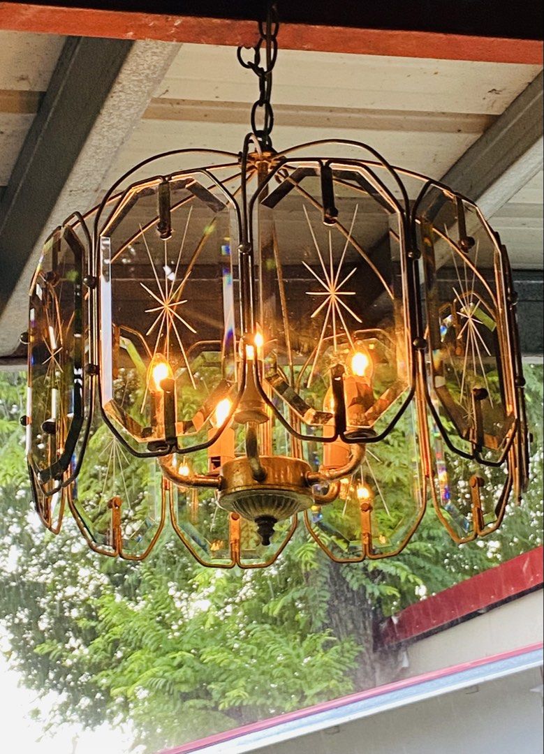 Vintage Chandelier (Category: Lighting) located in Cainta. Submitted by gonzagajuanclo (Listing ID 1466157351, Image 1). Description: Mid-century modern hanging lamp with brass frame and thick glass panels. Etched starburst designs on each glass piece catch the light beautifully. Multiple candelabra bulbs inside giving off a warm glow. Brass hardware shows nice vintage patina. Chain and ceiling mount included. Heavy fixture, needs proper installa