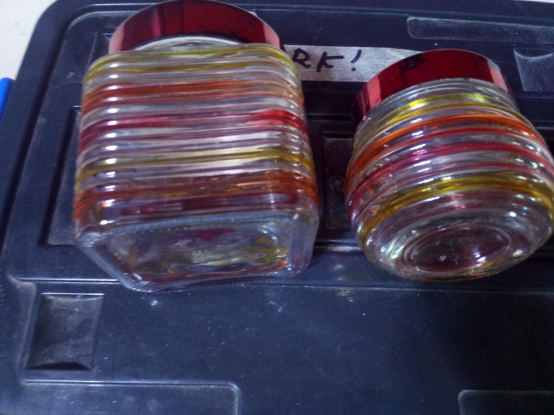 Vintage glass storage candy jars with red lids pair set (Category: Food Organization & Storage) located in Marikina City. Submitted by norman213 (Listing ID 1466236556, Image 2). Description: - Set of 2 decorative glass jars with eye-catching shiny red lids - Features vibrant horizontal stripes in yellow, orange, and red tones - Includes one square-shaped jar and one round-shaped jar - Perfect for kitchen storage, organizing small accessories, or