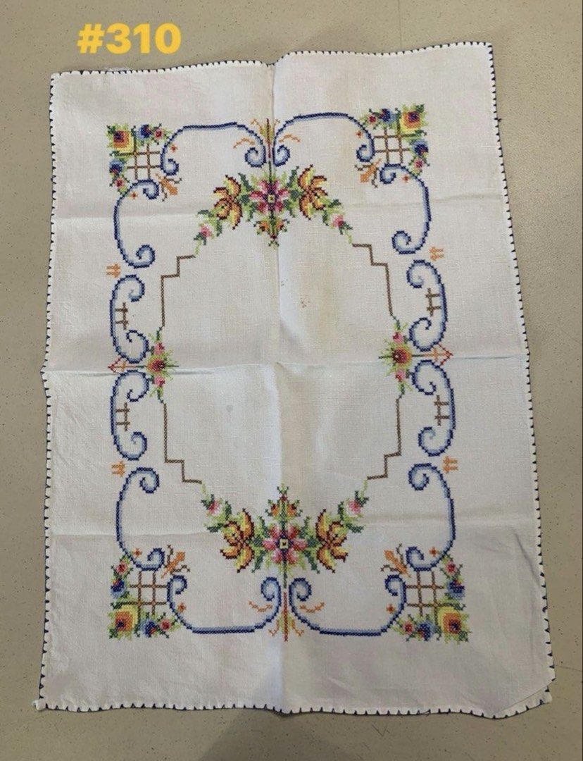 Vintage Hand-Embroidered Cross Stitch Table Runner (Category: Table Linen & Textiles) located in Quezon City. Submitted by meggoquingco (Listing ID 1466174784, Image 1). Description: - Hand-embroidered cross-stitch textile piece - Size: Approximately 39 cm x 52 cm - Design: Colorful floral motifs (yellow, pink, green) with intricate blue and brown borders - Finish: Scalloped dark blue edge all around - Flaws: A couple of faint yellowish marks nea