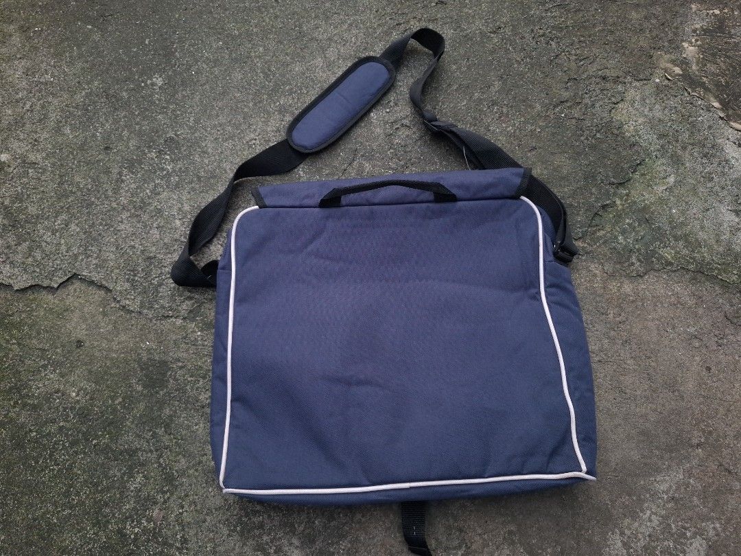 Vintage Reebok Messenger Bag Blue (Category: Sling Bags) located in Manila. Submitted by bonaobrag55538 (Listing ID 1466200538, Image 2). Description: Blue Reebok messenger bag with grey piping details and white embroidered logo. Front flap pocket with dual zippers, main compartment with inner dividers and Velcro strap. Adjustable shoulder strap featuring a padded section for comfort. Sturdy plastic buckle closure on the front flap..