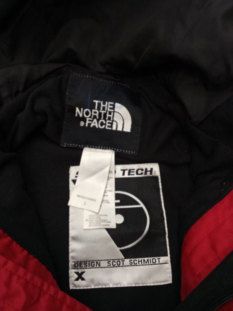 Vintage The North Face Steep Tech Red Black Jacket (Category: Coats, Jackets and Outerwear) located in Bogo. Submitted by thrift_kier (Listing ID 1466314750, Image 3). Description: - Brand: The North Face Steep Tech (Designed by Scot Schmid) - Size: Men's Large - Colorway: Red, grey, and black - Design: Heavy pocket detailing on the front with utility straps - Features: Multiple zip pockets and adjustable cuffs - Branding: Iconic branding on the 