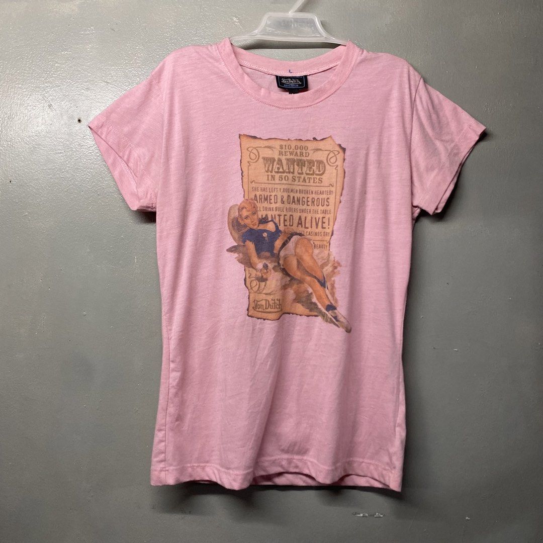 Von Dutch Pin-Up Wanted Graphic Tee Pink Medium (Category: Shirts) located in Cagayan de Oro. Submitted by sumamestreethub (Listing ID 1466247201, Image 1). Description: - Brand: Von Dutch Originals - Color: Light Pink - Size: Medium (true to size, slim fit) - Design: Vintage pin-up girl graphic with 'Wanted in 50 States' text - Details: Short sleeves, crew neck - Condition: Clean fabric, no stains, and print has no fading.