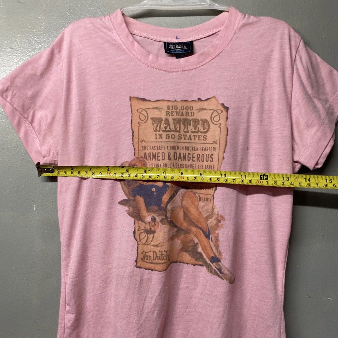 Von Dutch Pin-Up Wanted Graphic Tee Pink Medium (Category: Shirts) located in Cagayan de Oro. Submitted by sumamestreethub (Listing ID 1466247201, Image 3). Description: - Brand: Von Dutch Originals - Color: Light Pink - Size: Medium (true to size, slim fit) - Design: Vintage pin-up girl graphic with 'Wanted in 50 States' text - Details: Short sleeves, crew neck - Condition: Clean fabric, no stains, and print has no fading.