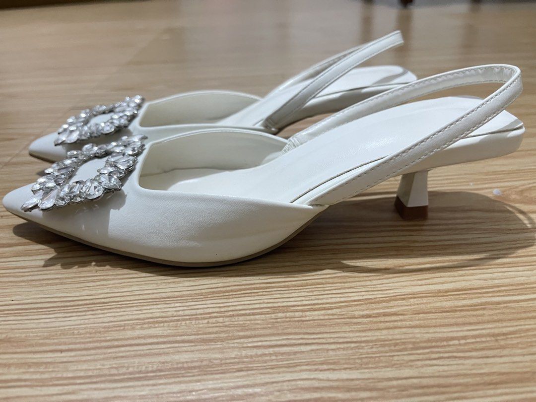 White slingback heels with crystal buckle size 36 (Category: Heels) located in Manila. Submitted by dyvmx949t543465 (Listing ID 1466245893, Image 2). Description: - Color: White - Style: Slingback heels with pointed toe and low kitten heel - Detail: Large rhinestone buckle on the front - Size: 36 (stamped on sole) - Condition: Worn once, minor wear on soles.