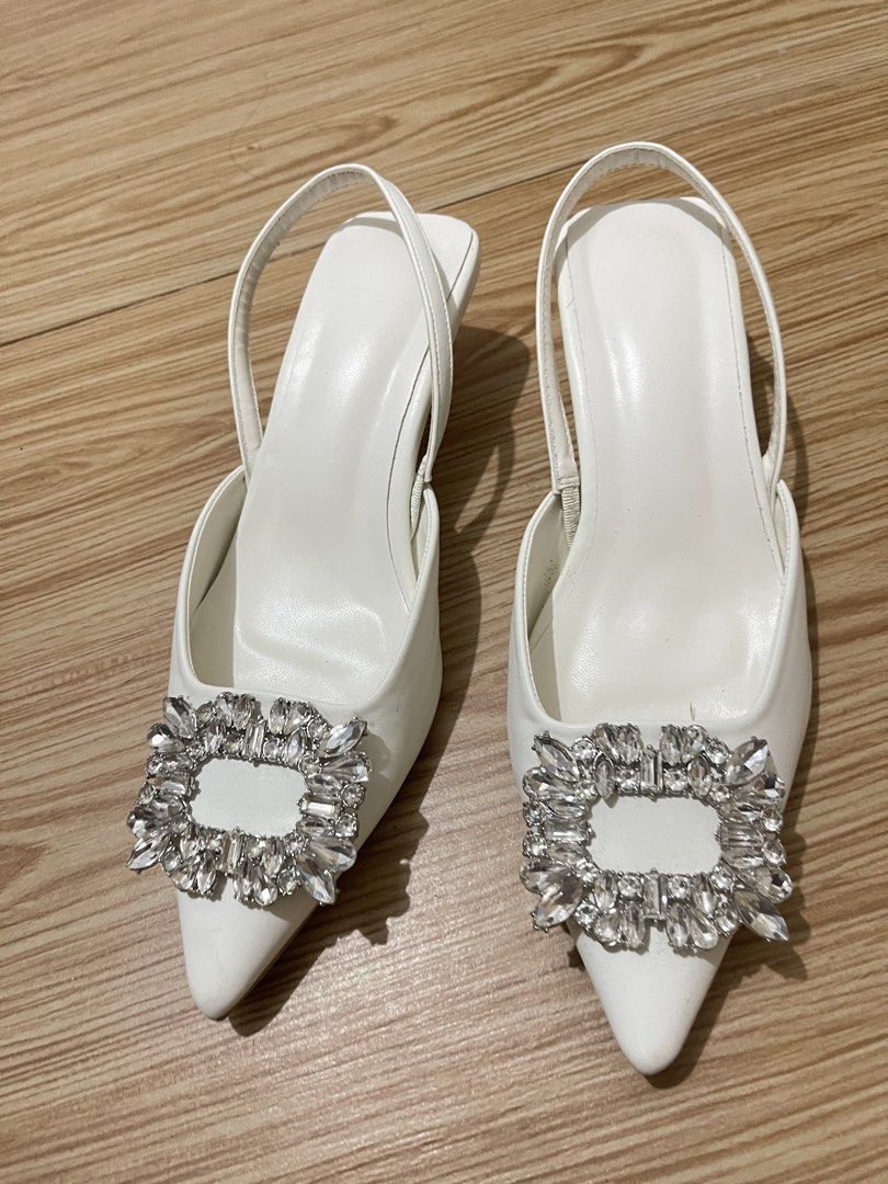 White slingback heels with crystal buckle size 36 (Category: Heels) located in Manila. Submitted by dyvmx949t543465 (Listing ID 1466245893, Image 1). Description: - Color: White - Style: Slingback heels with pointed toe and low kitten heel - Detail: Large rhinestone buckle on the front - Size: 36 (stamped on sole) - Condition: Worn once, minor wear on soles.