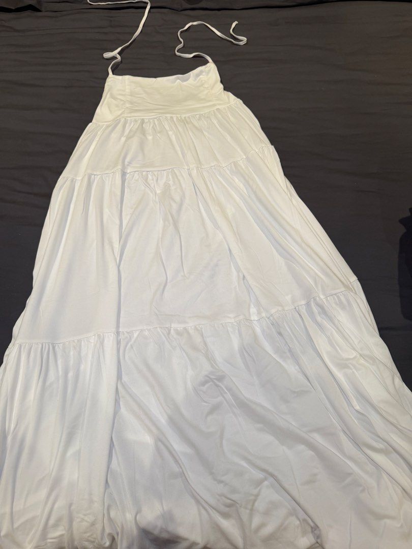 White tiered halter maxi dress (Category: Dresses) located in San Juan City. Submitted by ich711 (Listing ID 1466275421, Image 1). Description: - Color: White - Style: Halter neck maxi dress with thin tie straps - Design: Gathered bodice with a 3-tier flowy skirt - Material: Lightweight and breezy, perfect for warm weather - Versatility: Easy to dress up or down for beach trips or casual outings.