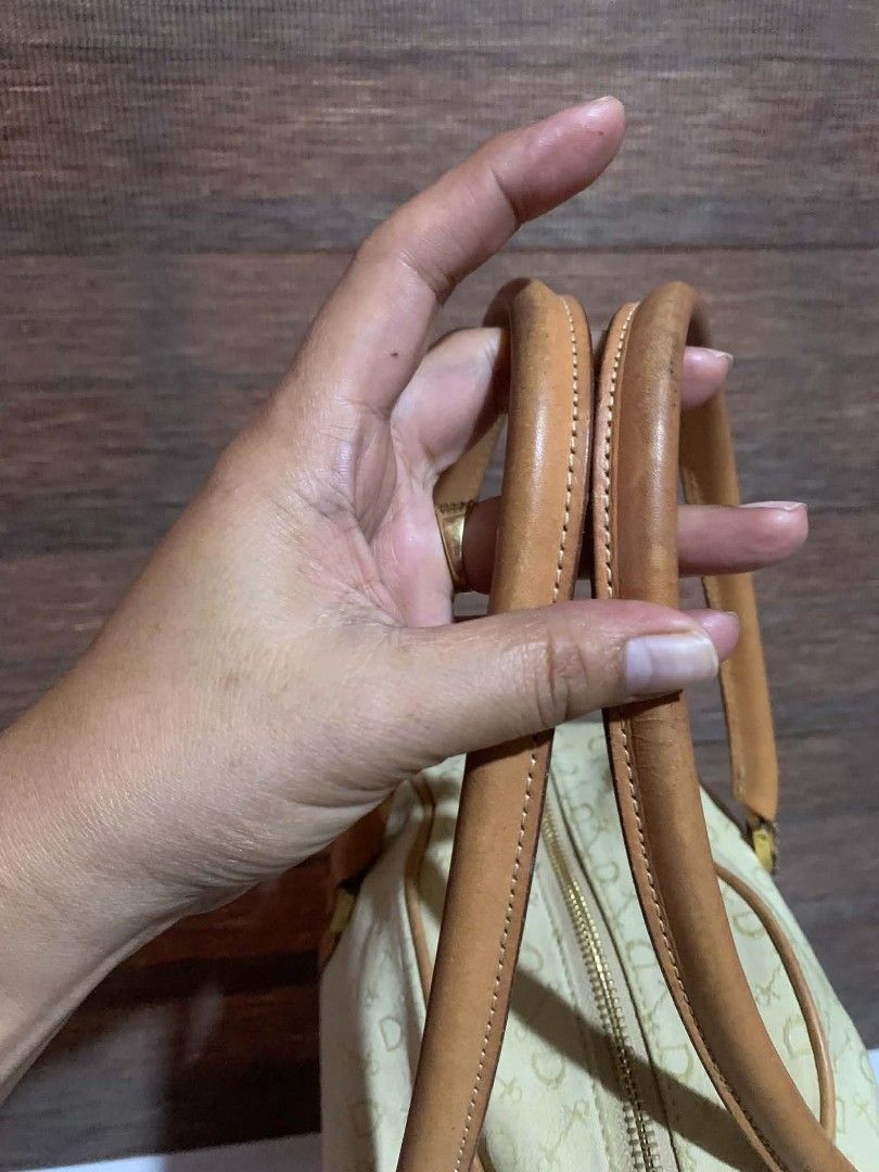 Why Leather Goods Speciality Monogram Handbag (Category: Luxury Bags & Wallets) located in Aliaga. Submitted by akishaoshop2010. (Listing ID 1466203008, Image 3). Description: - Cream fabric handbag with a stylish repeating key and stirrup pattern - Contrast tan leather handles and trim with structured bowling bag shape - Secure top zip closure featuring dual pull tabs and WHHL Leather Goods Speciality tag - Elegant gold-tone hardware and clean i