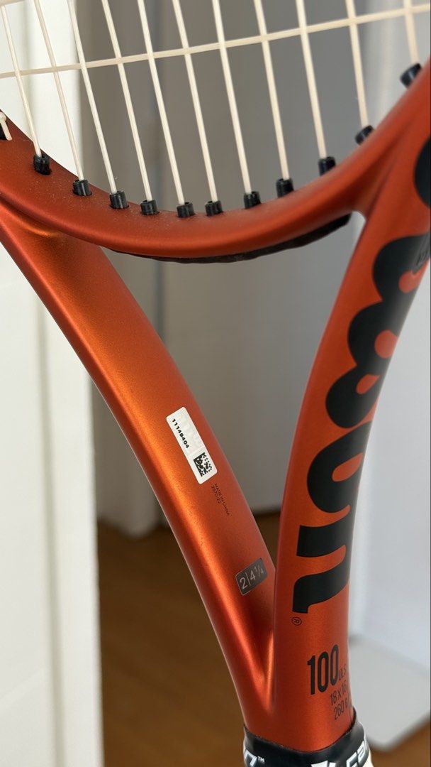 Wilson Burn 100ULS V5 Tennis Racket (Category: Racket and Ball Sports) located in San Fernando. Submitted by _gzel (Listing ID 1465983677, Image 3). Description: - Model: Wilson Burn 100ULS V5 - Color: Vibrant orange and black - Condition: Clean frame (no dent or scratches). Scratch on the bumper guard only (replaceable) - Setup: Strung - Grip: Original black grip tape still intact. With white overgrip - Performance: Solid option for players want